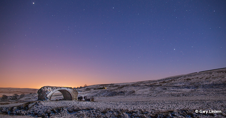 snow covered Durham dales and Rookhope Arch under starry night sky